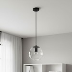 Czarna lampa wisząca Sarpo z jednym gniazdem E27, zawieszona na cienkim przewodzie. Szklany klosz w kształcie kuli, przezroczysty, z widoczną żarówką. Lampa montowana do sufitu, w minimalistycznym wnętrzu z jasnym tłem.