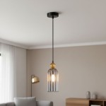 Lampa wisząca Narisa z czarnym metalowym stelażem i dymionym kloszem. W centralnej części znajduje się złota kulka. Produkt zawieszony na długim kablu, w minimalistycznym wnętrzu z podłogą w neutralnych kolorach.