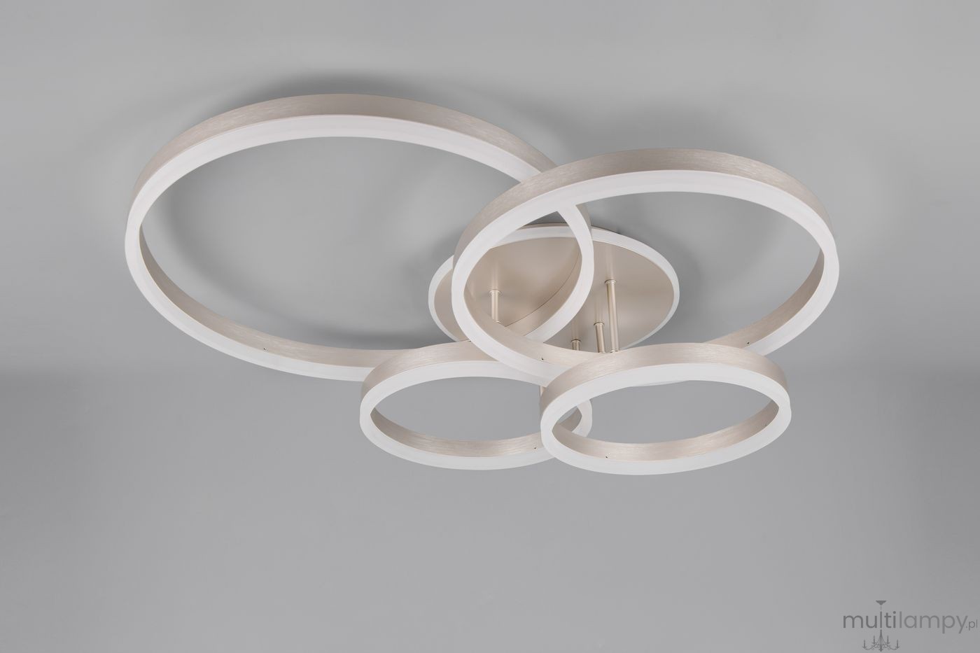 Lampa sufitowa Drake z pięcioma źródłami LED 50W w kolorze niklu. Składa się z trzech owalnych, białych pierścieni, umieszczonych na metalowej podstawie. Ujęcie z góry, na jednolitym szarym tle.