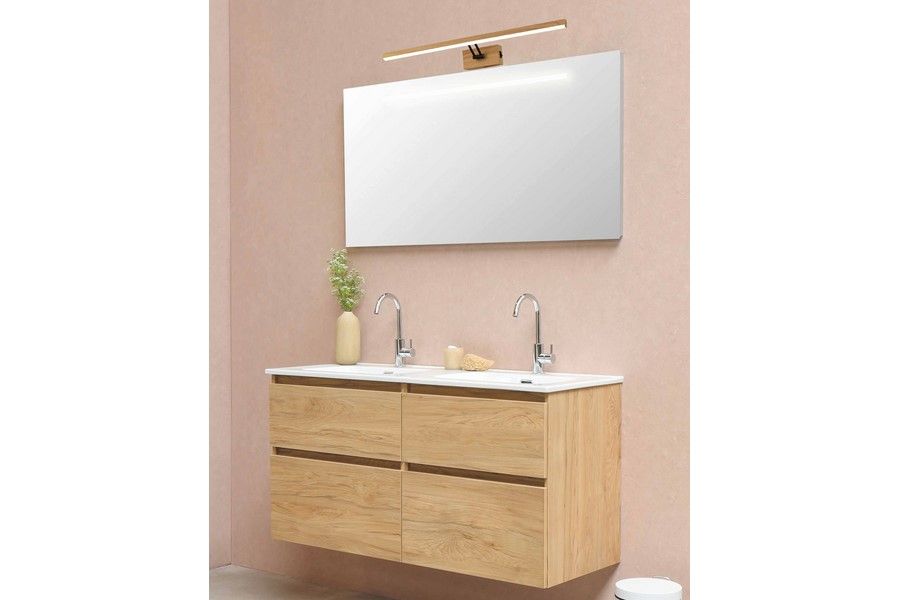 Lester kinkiet L60 LED 7W 4000K w kolorze złotym, zamontowany nad lustrem w nowoczesnej łazience. Oświetlenie z minimalistycznym designem na tle różowej ściany, w aranżacji z drewnianą szafką i umywalką.