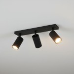 Lampa sufitowa Lucerno w kolorze czarnym z trzema reflektorami GU10, zamontowana na prostokątnej podstawie. Reflektory mają żebrowaną fakturę i są ustawione w różnych kierunkach, emitując ciepłe światło.
