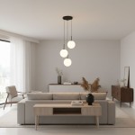 Lampa wisząca Deore 3xE27 w kolorze czarnym i białym, z trzema okrągłymi kloszami, wisząca na długich linkach. Umieszczona w nowoczesnym wnętrzu, nad sofą w jasnej aranżacji, obok drewnianego stolika i komody.