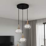 Lampa wisząca Konila 3-punktowa w kolorze czarnym i mosiądzu. Posiada trzy szklane klosze w kształcie kropli, zawieszone na czarnych linkach. Montowana do sufitu, idealna do nowoczesnych wnętrz. Ujęcie frontalne, na tle jasnej ściany.