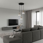 Lampa wisząca Konila 3-punktowa w czarnym kolorze z mosiężnymi detalami. Składa się z trzech szklanych kloszy o zaokrąglonym kształcie, zawieszonych na czarnych przewodach. Zawieszona z sufitu w nowoczesnym wnętrzu z telewizorem i sofą.