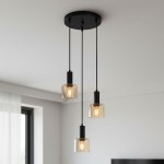 Lampa wisząca Santia 3-punktowa w kolorze czarnym z bursztynowymi kloszami. Trzy szklane klosze zawieszone na czarnych linkach, montowane do sufitu. Klosze mają okrągły kształt, a w środku widoczne żarówki. Tło jasne, minimalistyczne.