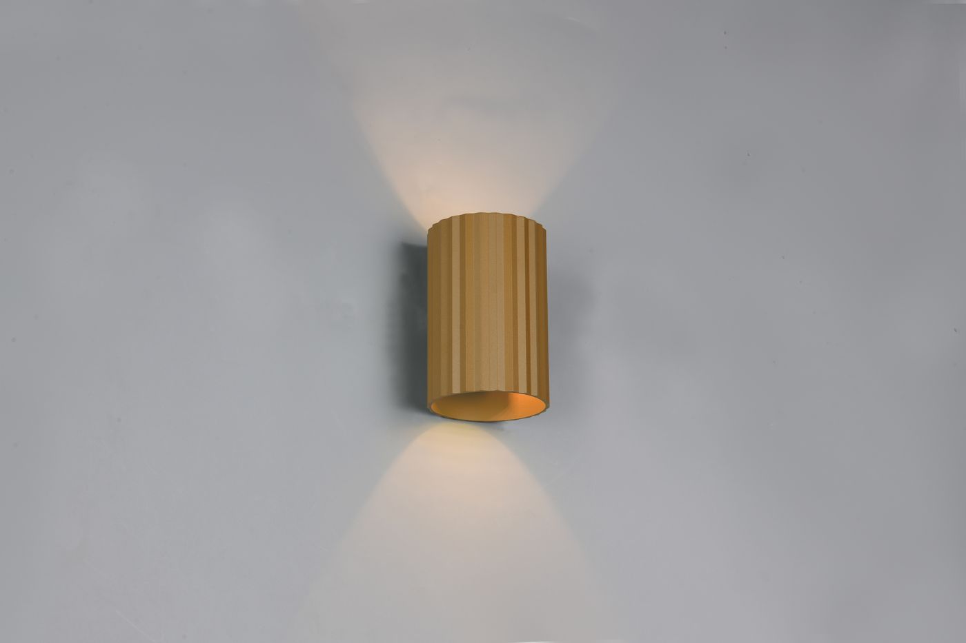 Kinkiet Imaria w kolorze kawowym, cylindryczny z fakturą, montowany na ścianie. Emituje światło w górę i w dół. Prosty design, idealny do nowoczesnych wnętrz. Tło jasnoszare, co podkreśla kolor lampy.