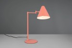 Lampa stołowa Cosima w kolorze morelowym z metalowym stelażem i stożkowym kloszem. Ujęcie frontalne, lampa stoi na okrągłej podstawie. Widoczny przewód zasilający. Idealna do biura lub wnętrz nowoczesnych.