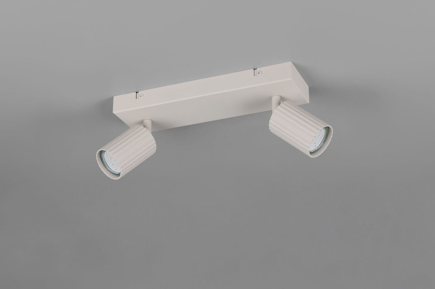 Lampa sufitowa Soka w kolorze szarym z dwoma ruchomymi reflektorami na prostokątnej podstawie. Reflektory mają żłobioną fakturę i są przeznaczone na żarówki GU10. Ujęcie z dołu, ukazujące całość konstrukcji.