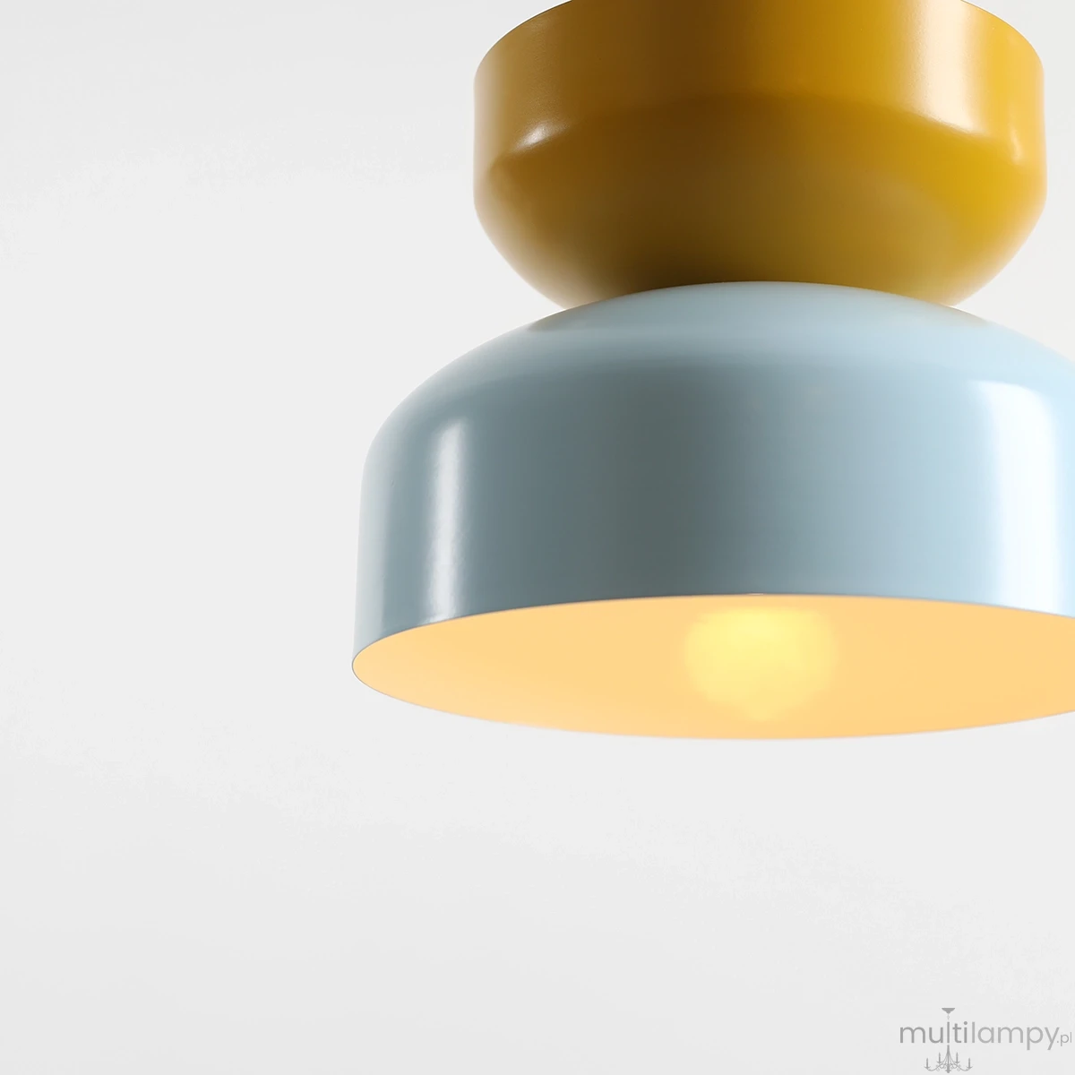 Lampa wisząca Tula 1xE27 w kolorze błękitnym i musztardowym, o okrągłym kształcie. Górna część w kolorze musztardowym, dolna błękitna z wewnętrzną, jasną powierzchnią. Ujęcie z bliska, pokazujące detale i fakturę materiału.