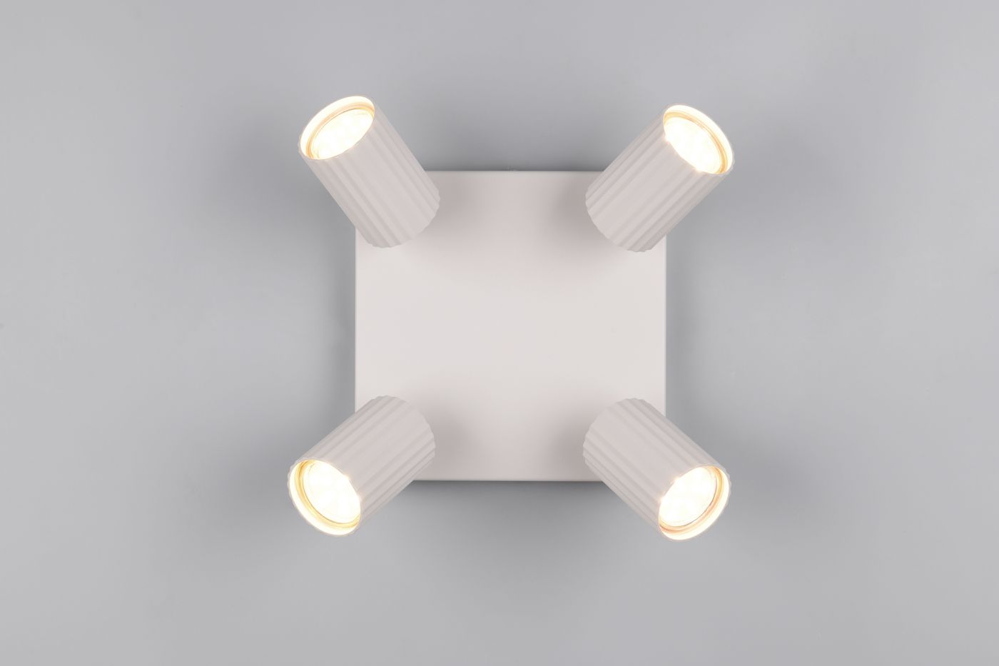 Lampa sufitowa Soka w kolorze szarym z czterema regulowanymi reflektorami GU10. Ujęcie z góry, pokazujące prostokątną podstawę i okrągłe klosze z rowkowaną fakturą. Idealna do oświetlenia wnętrz.