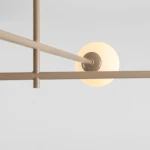 Beżowa lampa sufitowa Pinne z czterema miejscami na żarówki E14. Widok z dołu, ukazujący okrągły klosz oraz metalowe rury w minimalistycznym stylu. Tło jasne, co podkreśla kolor lampy.