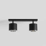 Czarna lampa sufitowa 2-punktowa z metalową konstrukcją, składająca się z dwóch cylindrycznych kloszy z przezroczystymi elementami. Ujęcie frontalne, zamontowana na prostej, płaskiej podstawie. Idealna do nowoczesnych wnętrz.