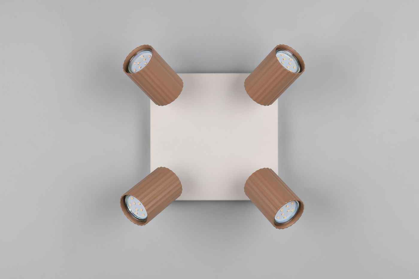 Lampa sufitowa Soka z czterema reflektorami GU10 w kolorze szarym i kawowym. Widok z góry, prostokątna metalowa podstawa z czterema cylindrycznymi kloszami z rowkowaną teksturą. Klosze skierowane w różne strony, gotowe do oświetlenia wnętrza.