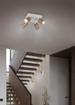 Lampa sufitowa Soka w kolorze szaro-kawowym z czterema reflektorami GU10. Reflektory w kształcie cylindrów, zamontowane na prostokątnej bazie. Produkt umieszczony w nowoczesnym wnętrzu z widoczną klatką schodową w tle.