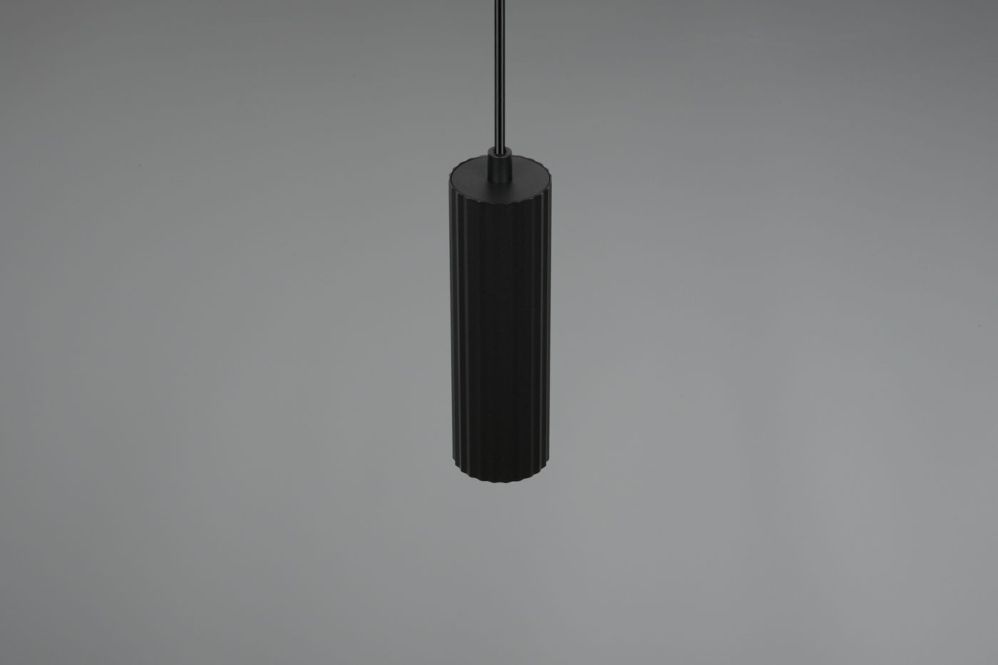 Czarna lampa wisząca Soka z jednym gniazdem GU10, o cylindrycznym kształcie z teksturowaną powierzchnią. Produkt zawieszony w pozycji pionowej na cienkim przewodzie, na jednolitym tle.