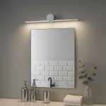 Kinkiet LED Artist L40,5 o mocy 6W i temperaturze barwowej 4000K, w chromowanej obudowie. Zainstalowany nad lustrem, emitujący neutralne światło, w otoczeniu akcesoriów łazienkowych na jasnym blacie.