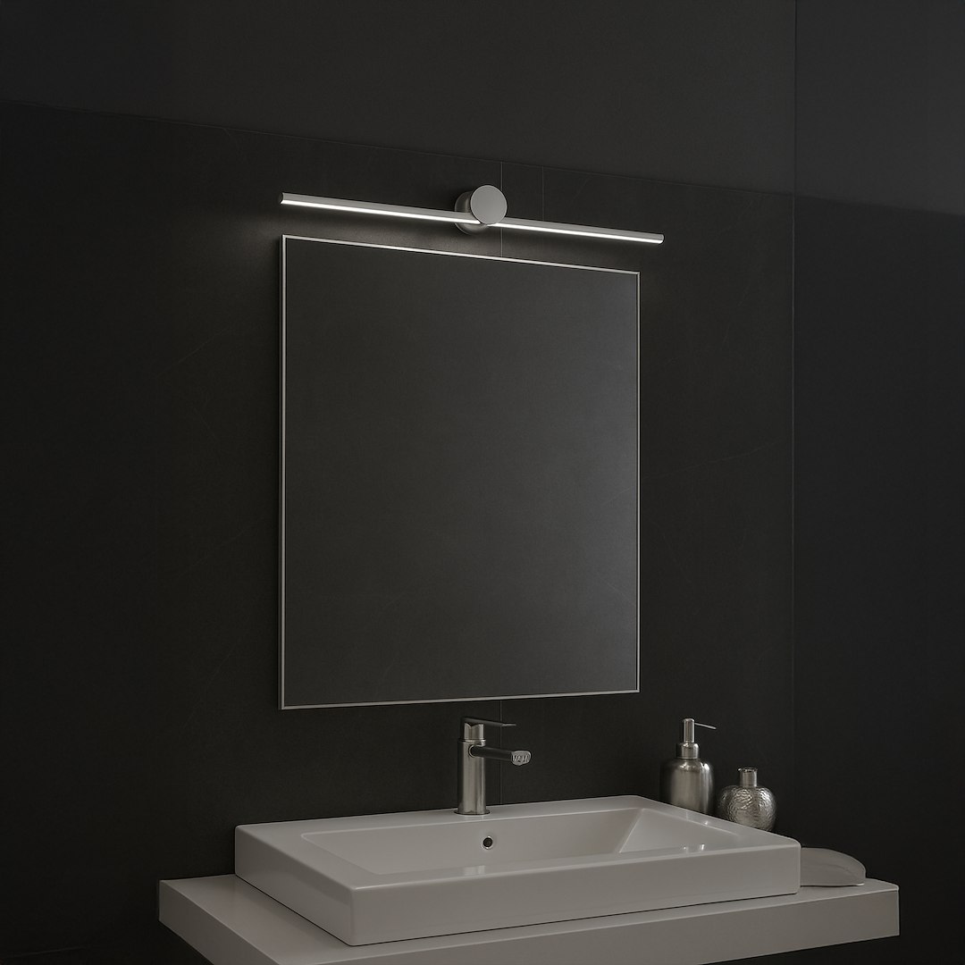 Kinkiet Artist L60,5 LED 9W 4000K IP44 w chromowanej obudowie, zamontowany nad prostokątnym lustrem. Oświetlenie w minimalistycznym stylu, z widoczną metalową konstrukcją, umieszczone na tle ciemnej ściany.
