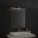 Kinkiet Artist L60,5 LED 9W 4000K IP44 w chromowanej obudowie, zamontowany nad prostokątnym lustrem. Oświetlenie w minimalistycznym stylu, z widoczną metalową konstrukcją, umieszczone na tle ciemnej ściany.