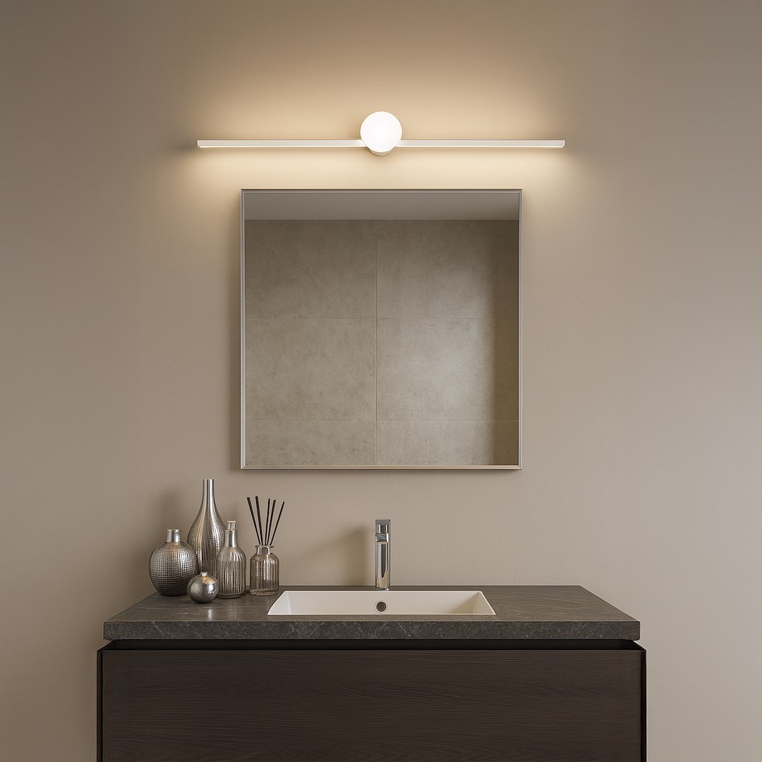 Kinkiet Artist L60,5 LED 9W 4000K IP44 w chromowanej obudowie umieszczony nad lustrem, emitujący jasne, neutralne światło. Zestawiony z ciemnym blatem i dekoracjami w odcieniach srebra na jasnym tle.