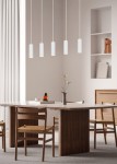 Lampa wisząca Soka z pięcioma cylindrycznymi kloszami w kolorze białym, zawieszona na cienkich linkach. Produkt umieszczony nad stołem w nowoczesnej aranżacji wnętrza, w tle widoczne drewniane meble i dekoracje.