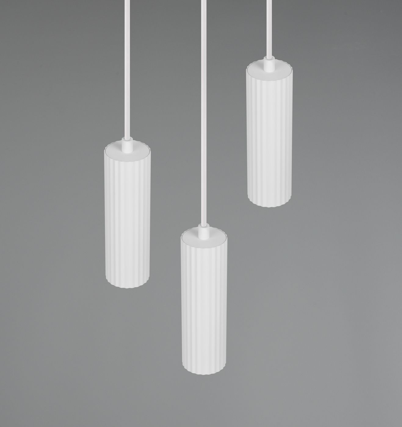 Lampa wisząca Soka w kolorze białym z trzema cylindrycznymi kloszami, o żebrowanej fakturze, zawieszona na białych linkach. Ujęcie z góry, na jednolitym szarym tle. Przeznaczona do żarówek GU10.