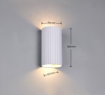 Kinkiet Soka w kolorze białym, cylindryczny, z rowkowaną powierzchnią. Wymiary: wysokość 180 mm, średnica 95 mm, głębokość 85 mm. Dwa miejsca na żarówki GU10, montowany na ścianie. Emituje światło w górę i w dół. Tło szare, proste.