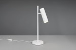 Lampa stołowa Soka w kolorze białym, z okrągłą podstawą i pionowym stelażem. Główka lampy w formie cylindrycznej, żłobkowanej, skierowana lekko w dół. Widoczny przewód z przełącznikiem. Ujęcie z boku na jednolitym tle.