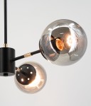 Lampa wisząca Gaja z trzema żarówkami E27 w czarnej i złotej kolorystyce. Elementy metalowe w matowym czarnym wykończeniu, szklane klosze w kształcie kul, z widocznymi żarówkami. Ujęcie z góry, ukazujące detale konstrukcji.