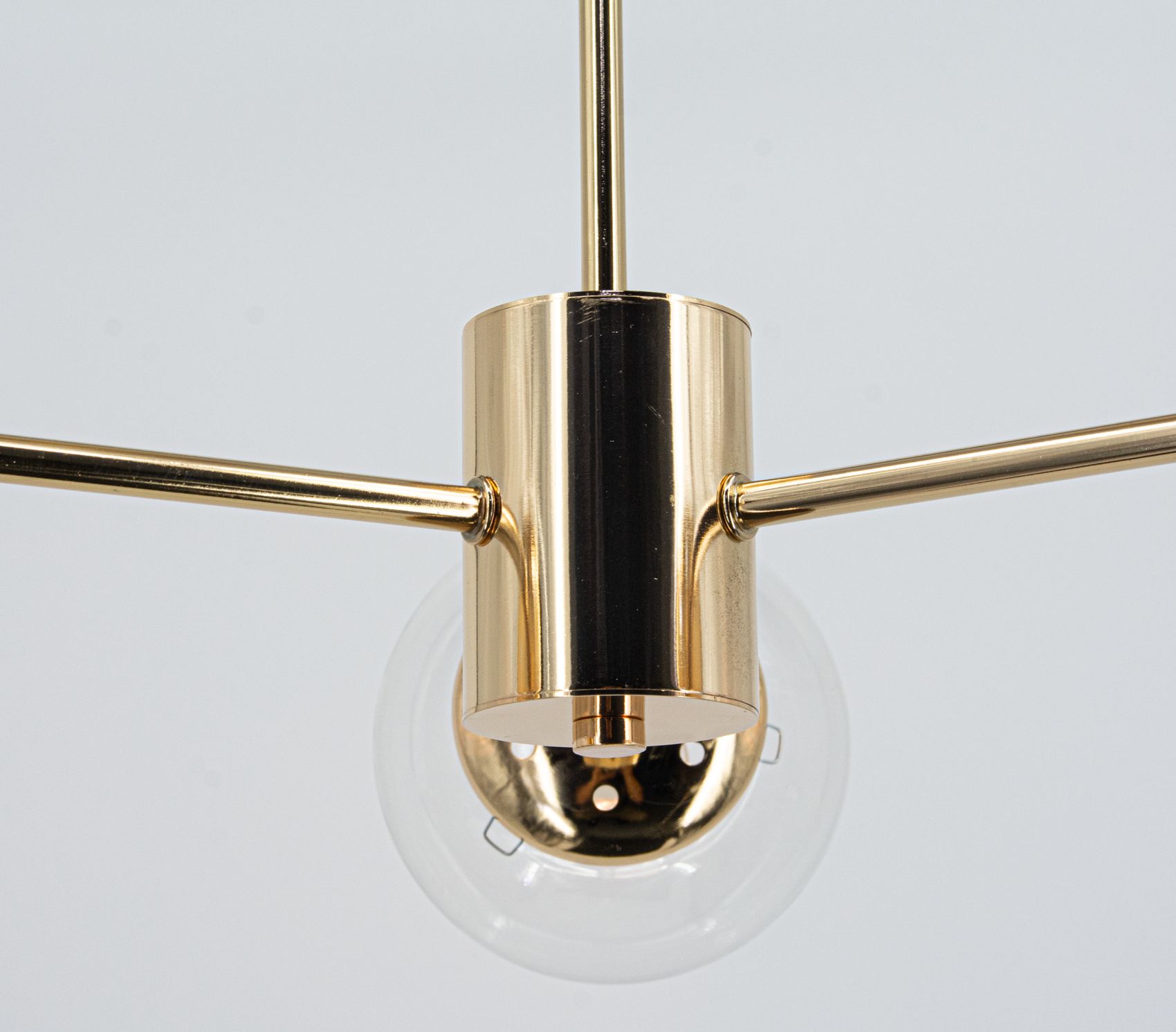 Lampa wisząca Gaja w kolorze złotym, z trzema ramionami na żarówki E27. Widok z dołu, ukazujący metalowy trzon i przezroczysty klosz. Elegancki design, idealna do nowoczesnych wnętrz.