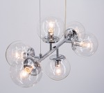 Lampa wisząca Paco z sześcioma kulistymi kloszami z przezroczystego szkła na chromowanej konstrukcji. Klosze umieszczone na metalowych ramionach, każda z żarówką E14, zawieszone na cienkim przewodzie. Tło jasne, minimalistyczne.