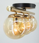 Lampa sufitowa Argo z trzema kloszami E14, złota i czarna. Klosze w kształcie kul, wykonane z przezroczystego szkła, montowane na metalowej, błyszczącej konstrukcji. Widoczna złota podstawa i czarny sufitowy uchwyt.