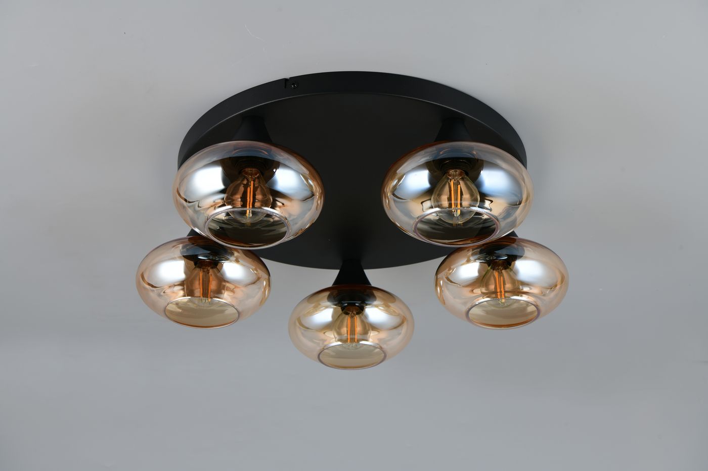 Lampa sufitowa Divina z pięcioma oprawami E14, w kolorze czarnym z bursztynowymi kloszami, umieszczona na okrągłej podstawie. Klosze mają zaokrąglony kształt, a lampa jest zamontowana na suficie.