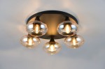 Lampa sufitowa Divina z pięcioma oprawami E14, czarna podstawa, bursztynowe klosze o okrągłym kształcie, zamontowana na suficie. Klosze przezroczyste, widoczne żarówki emitujące ciepłe światło.