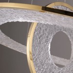 Lampa wisząca Alexia z dwoma źródłami LED 45W, w złotej oprawie. Kształt okręgu, z fakturowanym, przezroczystym kloszem w odcieniu szarości. Ujęcie z boku, pokazujące detale i unikalny design.