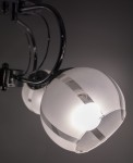 Lampa sufitowa Ruby z trzema kloszami E27 w chromowanej oprawie. Klosze o półprzezroczystej fakturze z metalicznymi paskami, zamontowane na elastycznych ramionach, widok z boku w zbliżeniu. Tło ciemne, podkreślające design lampy.