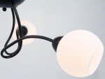 Lampa sufitowa Aria, czarna, z trzema oprawami E27. Widoczne białe klosze w kształcie kul, zawieszone na delikatnych, zakrzywionych ramionach. Ujęcie z boku, podkreślające elegancką formę i połączenie materiałów.
