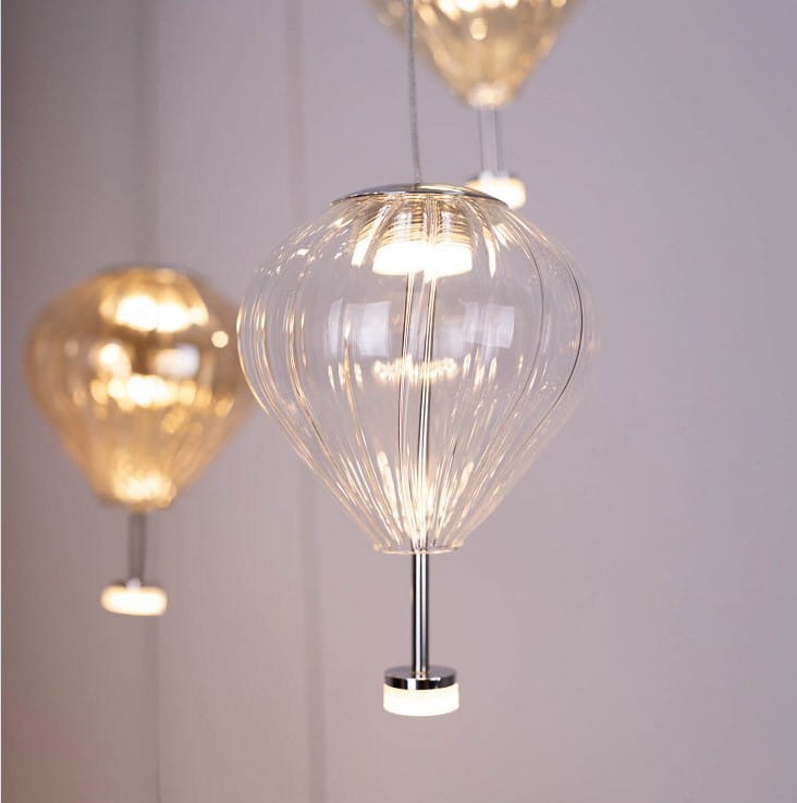 Lampa wisząca Palloncini z 11 diodami LED, 66W, w kolorze białym i multikolorowym. Okrągła, przezroczysta szkło o strukturze, zawieszona na cienkim przewodzie. Metalowy uchwyt z chromowanym wykończeniem, elegancko oświetlająca przestrzeń.