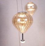 Lampa wisząca Palloncini z 11 diodami LED, o kształcie balonu. Szklany klosz w kolorze przezroczystym z delikatnymi prążkami, zawieszony na cienkim kablu. Na metalowej podstawie znajduje się mała, okrągła podstawa. Idealna do nowoczesnych wnętrz.