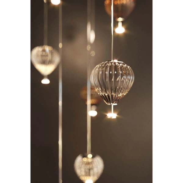 Lampa wisząca Palloncini z dwoma źródłami LED 6W, w kolorze białym i transparentnym. Ozdobne, szklane klosze w kształcie balonów, zawieszone na cienkich linkach, emitujące ciepłe światło. W tle ciemne, jednolite tło.