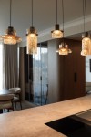 Lampa wisząca Signature z mosiężnym wykończeniem, z jednym źródłem LED 8W. Widoczne szklane klosze o różnym kształcie, zawieszone na czarnych przewodach w nowoczesnym wnętrzu kuchennej aranżacji.