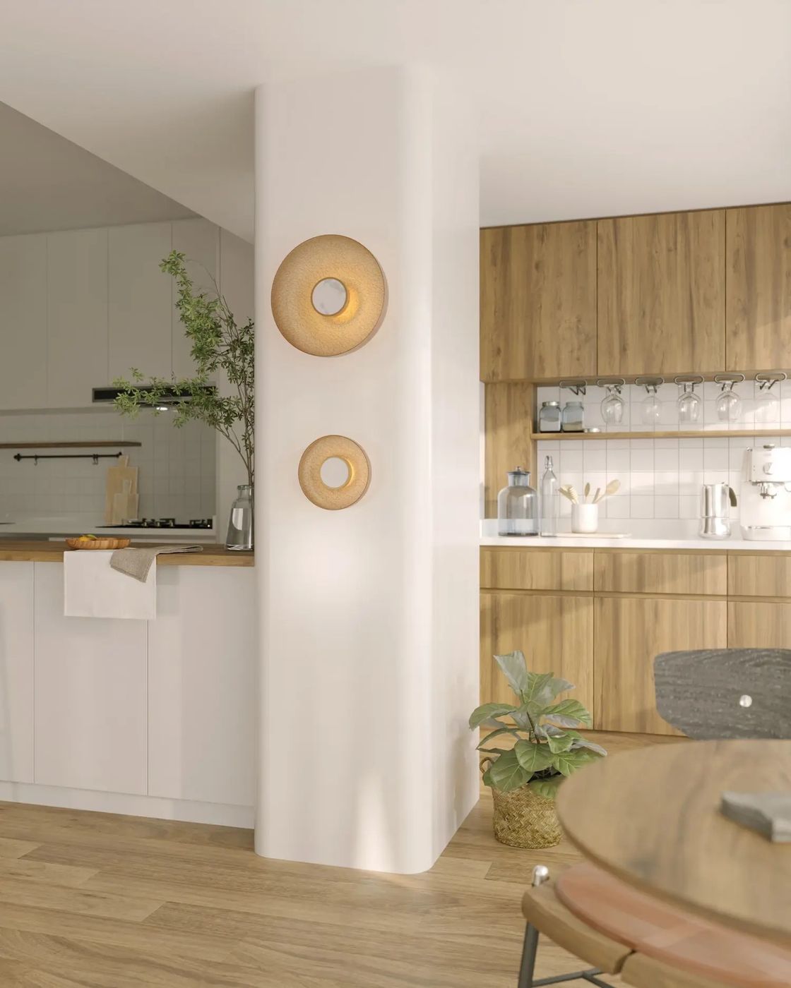 Kinkiet Signature z jedną diodą LED 9W w odcieniu mosiądzu, zamontowany na białej ścianie. Okrągły kształt z centralnym otworem, w zestawie z rośliną doniczkową w koszu. Tło w aranżacji kuchennej z drewnianymi szafkami.