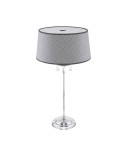 Lampa stołowa Egida z kloszem w szaro-srebrnym kolorze, z chromowaną podstawą. Posiada dekoracyjne kryształki zwisające u podstawy. Wysoka, elegancka konstrukcja z miejscem na żarówkę E27. Ujęcie frontalne, na jednolitym tle.