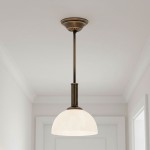 Lampa wisząca Delos D19 z metalowym wykończeniem w kolorze patyny, z białym kloszem w kształcie półkuli. Ujęcie frontalne, zawieszona na cienkim, prostym wsporniku, w jasnym wnętrzu. Idealna do nowoczesnych aranżacji.