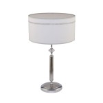 Lampa stołowa Julia II z satynowanego chromu, z okrągłym abażurem w kolorze białym, ozdobionym detalami. Stojąca na okrągłej podstawie, z pionowym, żłobkowanym trzonem oraz kryształowym akcentem w górnej części.