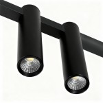 Lampa wisząca Kona z czterema punktami LED, 30W, w kolorze czarnym. Okrągłe oprawy z wyraźnym wzorem soczewki, zamontowane na prostokątnej belce. Kąt ujęcia zbliżeniowy, ukazujący detale konstrukcji.