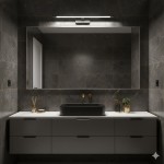 Kinkiet Klimt L60 LED 12W CCT IP44 w kolorze czarnym, zamontowany nad lustrem w nowoczesnej łazience. Oświetlenie LED z minimalistycznym designem, umieszczone na tle szarych płytek. Widoczna umywalka w ciemnym kolorze oraz złote akcenty.