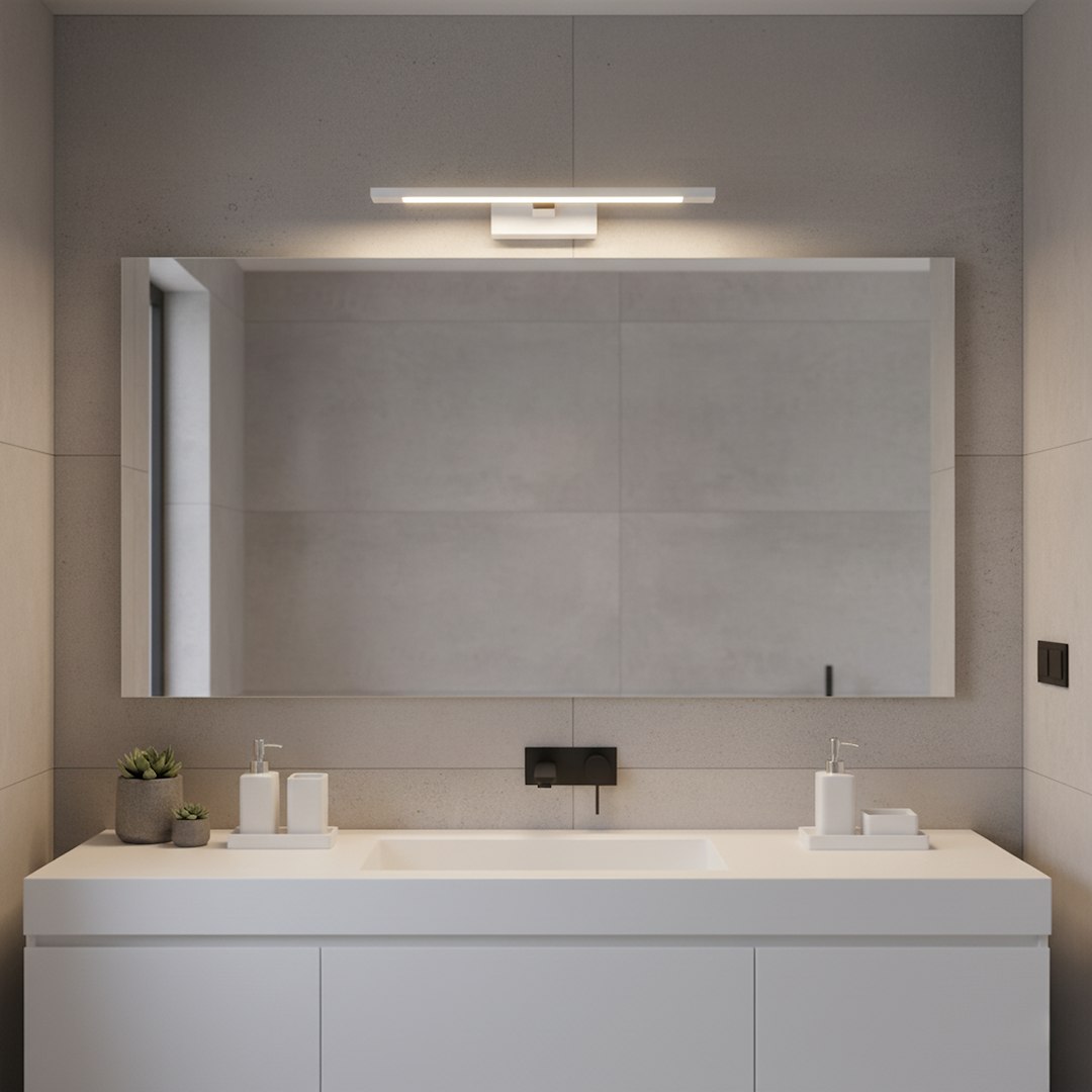 Kinkiet Klimt L40 LED 8W CCT IP44 w kolorze białym, zamontowany nad lustrem w nowoczesnej łazience. Prosty, prostokątny kształt, emitujący jasne światło. Tło w odcieniach szarości, minimalistyczne elementy dekoracyjne na blacie.