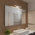 Kinkiet Klimt L40 LED 8W CCT IP44 w białej obudowie, zamontowany nad lustrem w nowoczesnej łazience. Prosty, prostokątny kształt, emitujący ciepłe światło, w otoczeniu drewnianych płytek i umywalki.