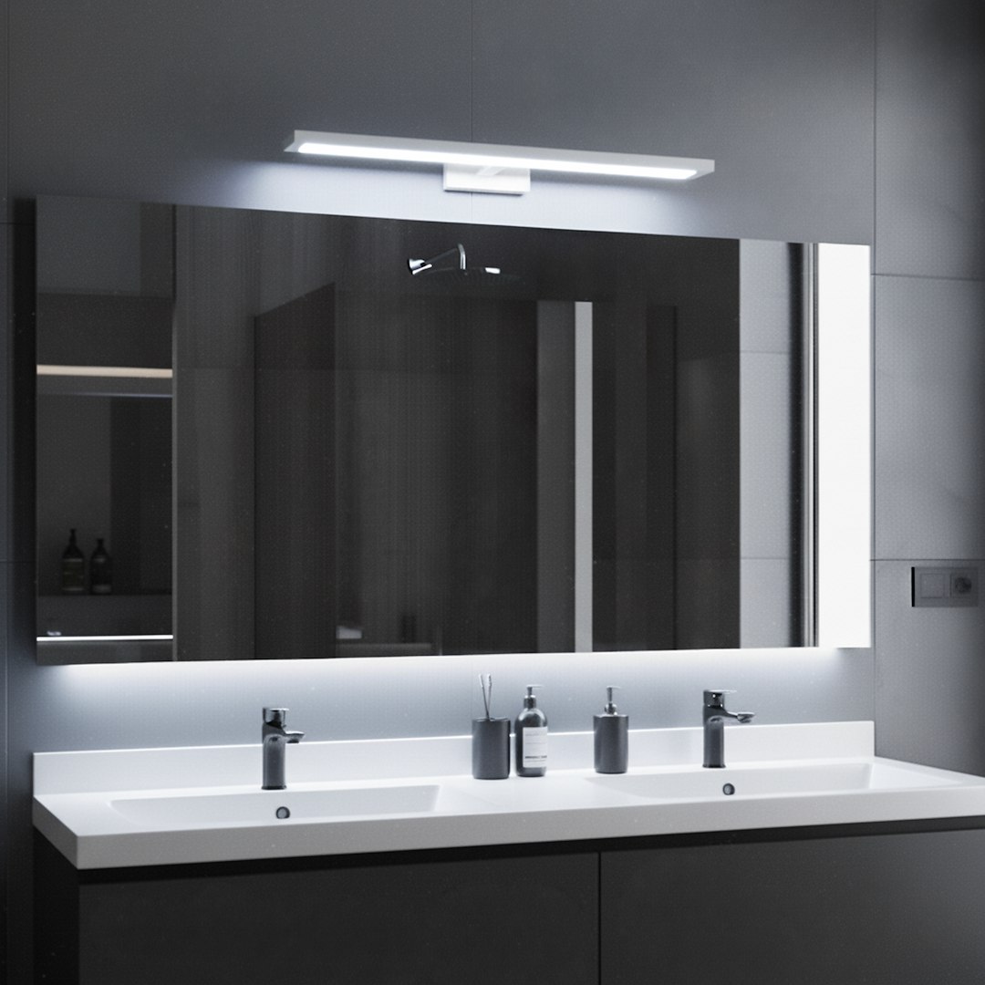 Kinkiet Klimt L60 LED 12W CCT IP44 w kolorze białym, zamontowany nad umywalką w łazience. Prosty, minimalistyczny design z prostokątną obudową, emitujący jasne światło. Tło w odcieniach szarości, z odbiciem w lustrze.