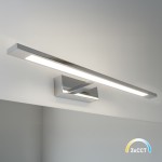 Kinkiet Klimt L60 LED 12W CCT w kolorze chromu, z prostokątną podstawą i cienką, poziomą oprawą świetlną. Produkt zamontowany na ścianie, emitujący światło w trzech temperaturach barwowych (CCT). Tło minimalistyczne, jasne.
